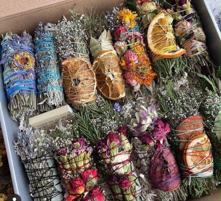Atados de hierbas con flores y rodajas de cítricos.
